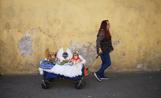 FILE - A woman pulls a cart with Baby Jesus figurines on Candlemas Day at the Xochimilco Catholic Church in Mexico City, Feb. 2, 2026. (AP Photo/Eduardo Verdugo, File)