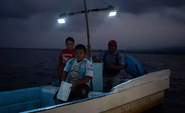 FILE - Fisherman Pancho Contreras sails at sea with young fishermen as night falls near Los Arrecifes, Mexico, Oct. 26, 2025. (AP Photo/Felix Marquez, File)