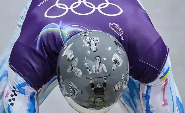 Ukraine's Vladyslav Heraskevych arrives at the finish during a men's skeleton training session at the 2026 Winter Olympics, in Cortina d'Ampezzo, Italy, Tuesday, Feb. 10, 2026. (AP Photo/Alessandra Tarantino)