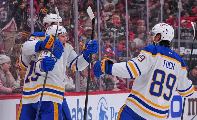 Buffalo Sabres' Peyton Krebs, center, celebrates with Tage Thompson, left, and Alex Tuch, right, after scoring a goal during the third period of an NHL hockey game against the New Jersey Devils Wednesday, Feb. 25, 2026, in Newark, N.J. (AP Photo/Frank Franklin II)