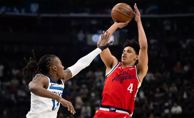 Los Angeles Clippers guard Kobe Sanders, right, shoots as Minnesota Timberwolves guard Ayo Dosunmu defends during the first half of an NBA basketball game Thursday, Feb. 26, 2026, in Inglewood, Calif. (AP Photo/Kyusung Gong)