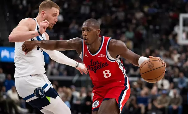 Los Angeles Clippers guard Kris Dunn, right, drives to the basket as Minnesota Timberwolves guard Donte DiVincenzo, left, defends during the first half of an NBA basketball game Thursday, Feb. 26, 2026, in Inglewood, Calif. (AP Photo/Kyusung Gong)