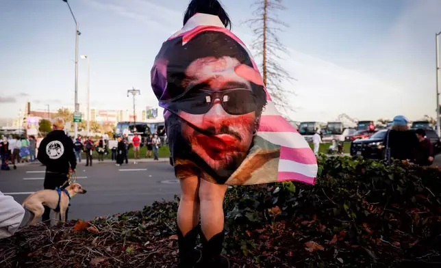 Kenia Medal wears a Bad Bunny flag while waiting to watch the halftime show outside Levi's Stadium during the NFL Super Bowl 60 football game between the Seattle Seahawks and the New England Patriots in Santa Clara, Calif., Sunday, Feb. 8, 2026. (Brontë Wittpenn/San Francisco Chronicle via AP)