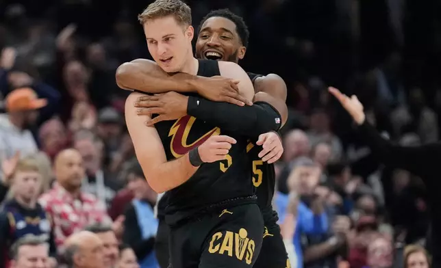 Cleveland Cavaliers guard Donovan Mitchell, right, celebrates with teammate Sam Merrill, left, in the first half of an NBA basketball game against the Washington Wizards in Cleveland, Wednesday, Feb. 11, 2026. (AP Photo/Sue Ogrocki)