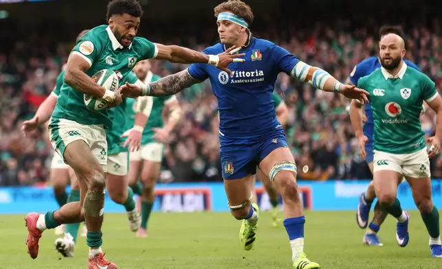 Ireland's Robert Baloucoune, left, runs onto score a try despite Italy's Lorenzo Cannone's late defence during a Six Nations rugby union match between Ireland and Italy in Dublin, Ireland, Saturday, Feb. 14, 2026. (AP Photo/Peter Morrison)