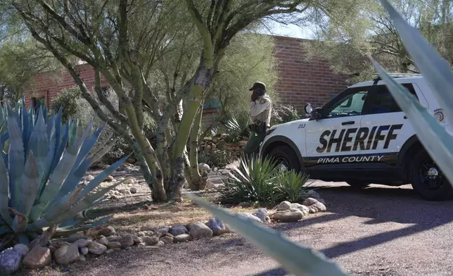 A Pima County sheriffs official stays outside of Nancy Guthrie‘s home on Saturday, Feb. 14, 2026 in Tucson, Ariz. (AP Photo/Ty O'Neil)