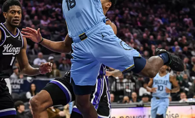 Memphis Grizzlies forward Olivier-Maxence Prosper (18) is fouled by Sacramento Kings center Dylan Cardwell during the first half of an NBA basketball game, Wednesday, Feb. 4, 2026, in Sacramento, Calif. (AP Photo/Justine Willard)