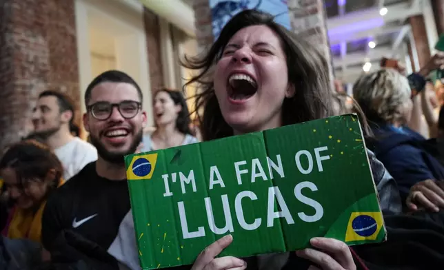 Supporters of Brazil's Lucas Pinheiro Braathen react at the Brazil House as he wins the men's giant slalom at the 2026 Winter Olympics, in Milan, Italy, Saturday, Feb. 14, 2026. (AP Photo/Antonio Calanni)