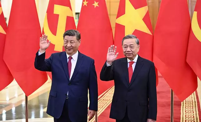 FILE - Vietnam's Communist Party General Secretary To Lam, right, and Chinese President Xi Jinping wave during a meeting at the Office of the Party Central Committee in Hanoi, Vietnam, April 14, 2025. (Nhac Nguyen/Pool Photo via AP, File)