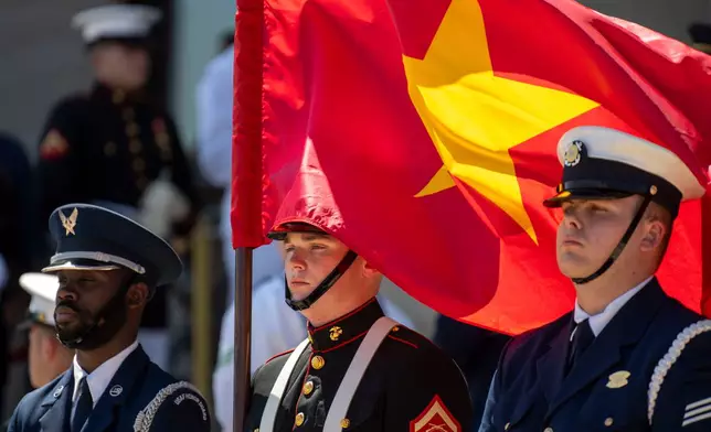 FILE - A U.S. Marine honor guard member holds the Vietnamese flag during an honor cordon at the Pentagon to welcome Vietnamese Defense Minister Gen. Phan Van Giang, Sept. 9, 2024, in Washington. (AP Photo/Kevin Wolf, File)