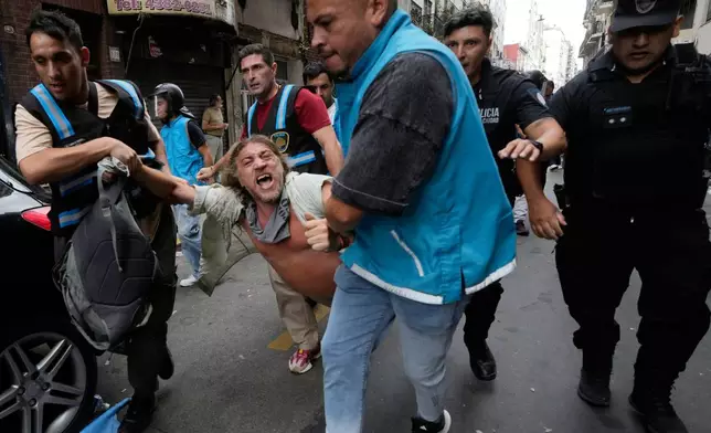 Police detain a protester during a march by trade unions and opposition groups protesting a labor reform bill proposed by President Javier Milei's government in Buenos Aires, Argentina, Wednesday, Feb. 11, 2026. (AP Photo/Gustavo Garello)