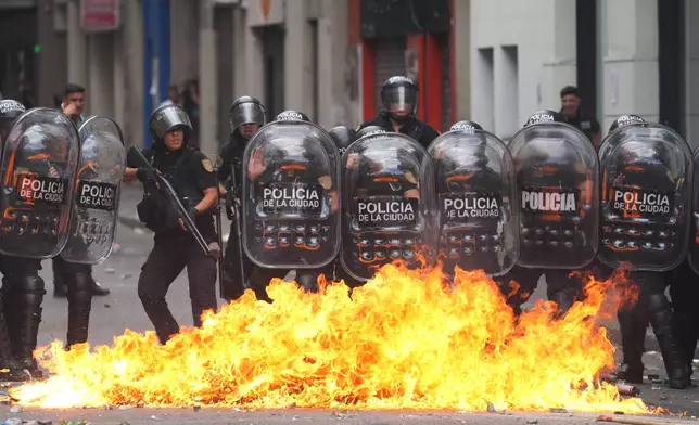 A Molotov cocktail bursts into flames in front of police during a march by unions and opposition supporters against a labor reform bill proposed by President Javier Milei's government in Buenos Aires, Argentina, Wednesday, Feb. 11, 2026.(AP Photo/Rodrigo Abd)