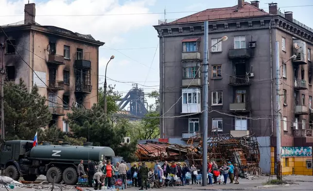 Civilians gather to receive drinking water distributed by the Russian Emergency Situations Ministry in Mariupol on May 27, 2022, after the seaside city in eastern Ukraine fell to Moscow's troops. (AP Photo, File)