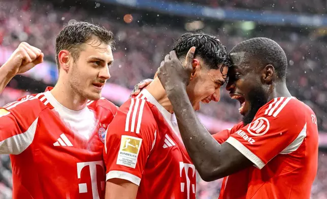 Bayern Munich's Aleksandar Pavlovic, center, celebrates scoring with Josip Stanisic, left, and Dayot Upamecano during the Bundesliga soccer match between Bayern Munich and Eintracht Frankfurt in Munich, Germany, Saturday Feb. 21, 2026. (Harry Langer/dpa via AP)