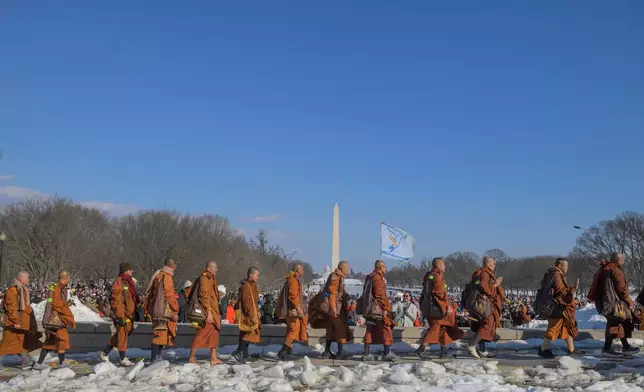 Buddhist monks who are participating in a Walk for Peace, walk near the Lincoln Memorial, in Washington, Wednesday, Feb., 11, 2026. (AP Photo/Rod Lamkey, Jr.)