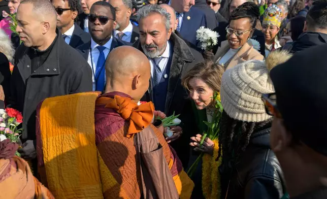 House Minority Leader Hakeem Jeffries, D-N.Y. , left, and Rep. Nancy Pelosi, D-Calif., right, greet Buddhist monks as they walk near the Peace Monument on Capitol Hill, during the Walk for Peace, in Washington, Wednesday, Feb., 11, 2026. (AP Photo/Rod Lamkey, Jr.)