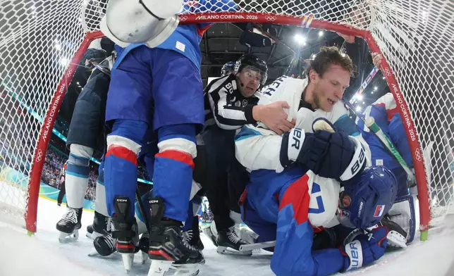 Finland's Eetu Luostarinen (27) top and Slovakia's Simon Nemec (17) bottom scuffle in the second period during a preliminary round match of men's ice hockey the 2026 Winter Olympics, in Milan, Italy, Wednesday, Feb. 11, 2026. (Bruce Bennett/Pool Photo via AP)