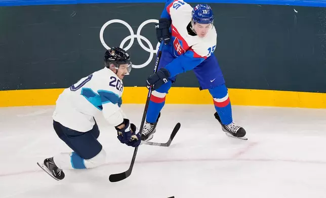 Finland's Sebastian Aho (20), left, challenges Slovakia's Dalibor Dvorsky (15) during a preliminary round match of men's ice hockey between Slovakia and Finland at the 2026 Winter Olympics, in Milan, Italy, Wednesday, Feb. 11, 2026. (AP Photo/Petr David Josek)