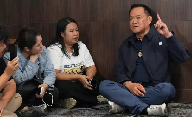 Thailand's Prime Minister and leader of Bhumjaithai Party Anutin Charnvirakul, right, speaks with journalists at the party headquarters while waiting for the results in the general election in Bangkok, Sunday, Feb. 8, 2026. (AP Photo/Sakchai Lalit)