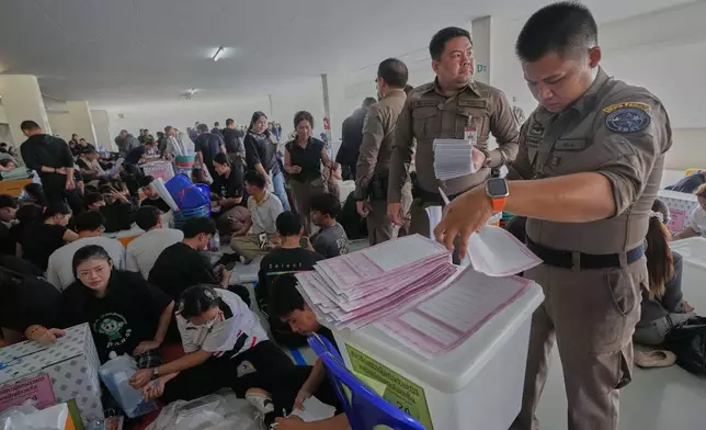 Police officers and Volunteers check ballots for Sunday's general election in Bangkok, Thailand, Saturday, Feb. 7, 2026. (AP Photo/Sakchai Lalit)