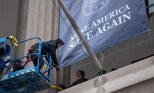 A banner showing President Donald Trump is hung from the Department of Justice, Thursday, Feb. 19, 2026, in Washington. (AP Photo/Allison Robbert)