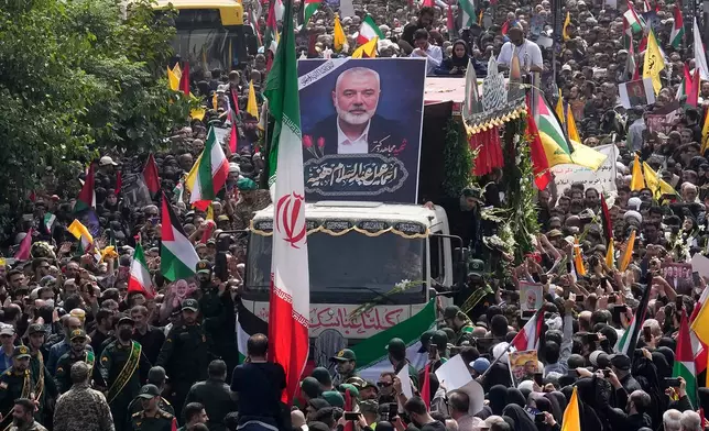 FILE - Iranians follow a truck, center, carrying the coffins of Hamas leader Ismail Haniyeh and his bodyguard who were killed in an assassination blamed on Israel, during their funeral ceremony at Enqelab-e-Eslami (Islamic Revolution) Sq. in Tehran, Iran, Aug. 1, 2024. (AP Photo/Vahid Salemi, File)