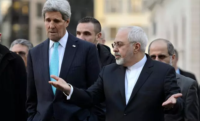 FILE - U.S. Secretary of State John Kerry, left, listens to Iranian Foreign Minister Mohammad Javad Zarif as they walk in the city of Geneva, Switzerland, Jan. 14, 2015, during a bilateral meeting ahead of the next round of nuclear discussions. (Martial Trezzini/Keystone via AP, File)