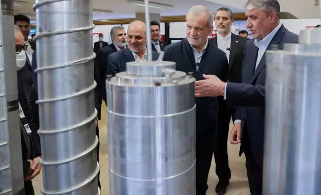 FILE - In this photo released by the Iranian Presidency Office, President Masoud Pezeshkian, second right, listens to the head of Atomic Energy Organization of Iran Mohammad Eslami as he visits an exhibition of Iran's nuclear achievements, in Tehran, Iran, on April 9, 2025. (Iranian Presidency Office via AP, File)