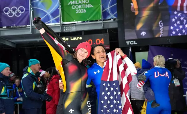 Germany's silver medalist Laura Nolte, left, and United States' gold medalist Elana Meyers Taylor, right, celebrate at the finish after the women's monobob competition at the 2026 Winter Olympics, in Cortina d'Ampezzo, Italy, Monday, Feb. 16, 2026. (AP Photo/Alessandra Tarantino)