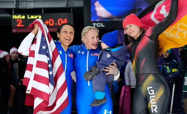 From let, United States' gold medalist Elana Meyers Taylor, United States' bronze medalist Kaillie Armbruster Humphries and Germany's silver medalist Laura Nolte celebrate at the finish after the women's monobob competition at the 2026 Winter Olympics, in Cortina d'Ampezzo, Italy, Monday, Feb. 16, 2026. (AP Photo/Alessandra Tarantino)