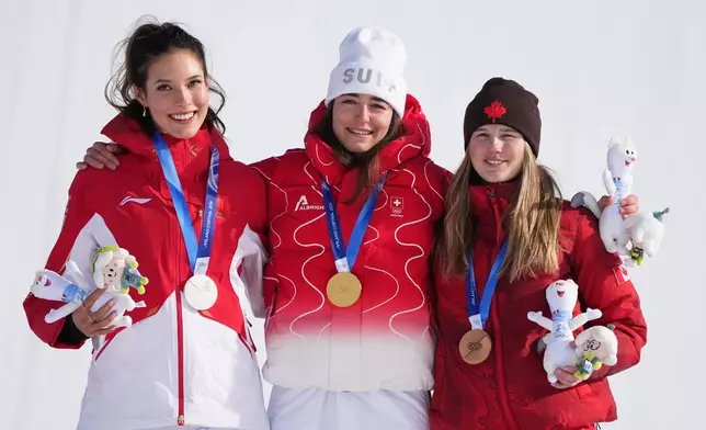 From left, silver medalist China's Eileen Gu, gold medalist Switzerland's Mathilde Gremaud and bronze medalist Canada's Megan Oldham celebrate after the women's freestyle skiing slopestyle finals at the 2026 Winter Olympics, in Livigno, Italy, Monday, Feb. 9, 2026. (AP Photo/Gregory Bull)