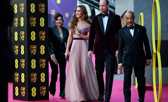 Britain's Prince William and Kate, Princess of Wales arrive with Jane Millichip, CEO of the British Academy of Film and Television Arts and Lord-Lieutenant of Greater London Ken Olisa to the 79th British Academy Film Awards, at the Royal Festival Hall, in London, Sunday Feb. 22, 2026. (Jaimi Joy/Pool Photo via AP)