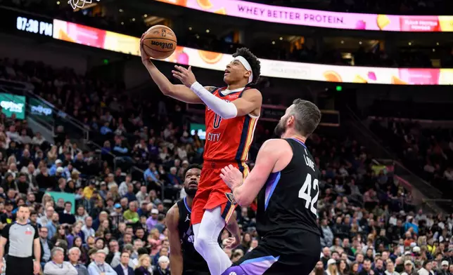 New Orleans Pelicans guard Jeremiah Fears (0) goes to the basket for a layup past the defense of Utah Jazz forward Kevin Love (42) during the first half of an NBA basketball game, Thursday, Feb. 26, 2026, in Salt Lake City. (AP Photo/Tyler Tate)