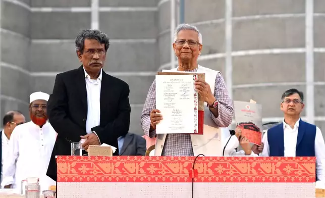 *Head of the Bangladesh's interim government and Nobel laureate Dr. Muhammad Yunus, center, displays a political charter called 'July National Charter' at an event outside Bangladesh's national parliament complex in Dhaka, Bangladesh, Friday, Oct. 17, 2025. (AP Photo/Mahmud Hossain Opu, File)
