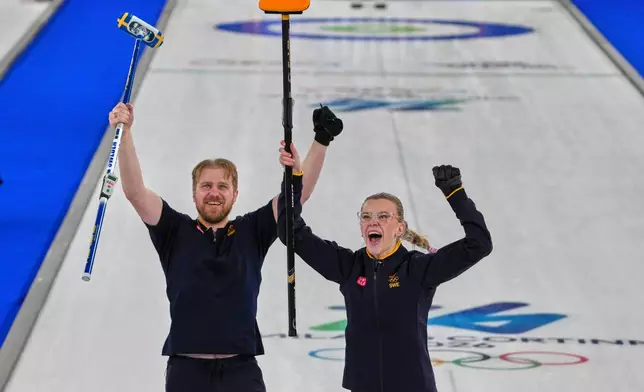 Sweden's Rasmus Wranaa and Isabella Wranaa celebrate after winning the gold medal mixed doubles curling match against USA, at the 2026 Winter Olympics, in Cortina D'Ampezzo, Italy, Tuesday, Feb. 10, 2026. (AP Photo/Misper Apawu)