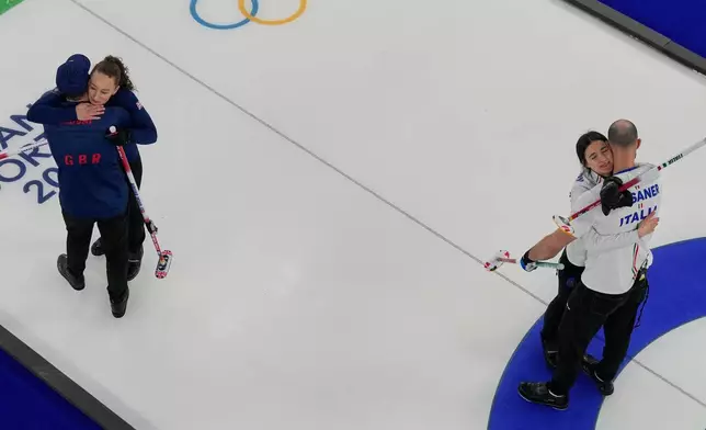 Italy's Amos Mosaner and Stefania Constantini, right, celebrate after winning the bronze medal mixed doubles curling match Britain's Bruce Mouat and Jennifer Dodds at the 2026 Winter Olympics, in Cortina d'Ampezzo, Italy, Tuesday, Feb. 10, 2026. (AP Photo/Bernat Armangue)