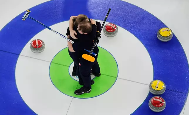 Sweden's Rasmus Wranaa and Isabella Wranaa, left, celebrate after winning the curling mix doubles gold medal match against United States at the 2026 Winter Olympics, in Cortina d'Ampezzo, Italy, Tuesday, Feb. 10, 2026. (AP Photo/Bernat Armangue)