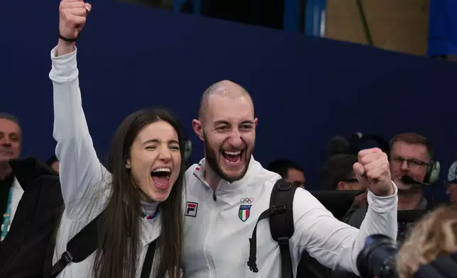 Italy's Amos Mosaner and Stefania Constantini celebrate after winning the bronze medal mixed doubles curling match against Britain, at the 2026 Winter Olympics, in Cortina D'Ampezzo, Italy, Tuesday, Feb. 10, 2026. (AP Photo/Misper Apawu)