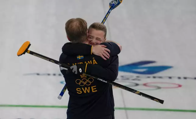 Sweden's Rasmus Wranaa and Isabella Wranaa celebrate after winning the gold medal mixed doubles curling match against USA, at the 2026 Winter Olympics, in Cortina D'Ampezzo, Italy, Tuesday, Feb. 10, 2026. (AP Photo/Misper Apawu)