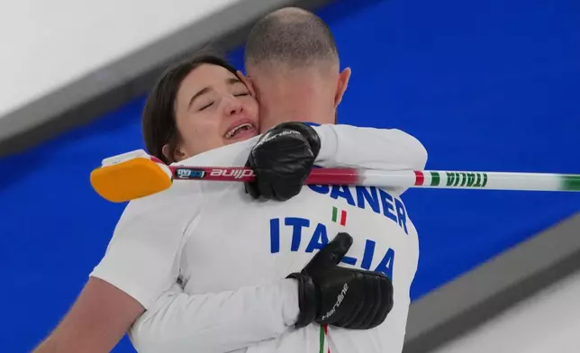 Italy's Amos Mosaner and Stefania Constantini celebrate after winning the bronze medal mixed doubles curling match against Britain, at the 2026 Winter Olympics, in Cortina D'Ampezzo, Italy, Tuesday, Feb. 10, 2026. (AP Photo/Misper Apawu)