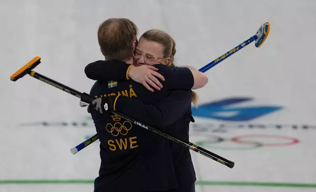 Sweden's Rasmus Wranaa and Isabella Wranaa celebrate after winning the gold medal mixed doubles curling match against USA, at the 2026 Winter Olympics, in Cortina D'Ampezzo, Italy, Tuesday, Feb. 10, 2026. (AP Photo/Misper Apawu)
