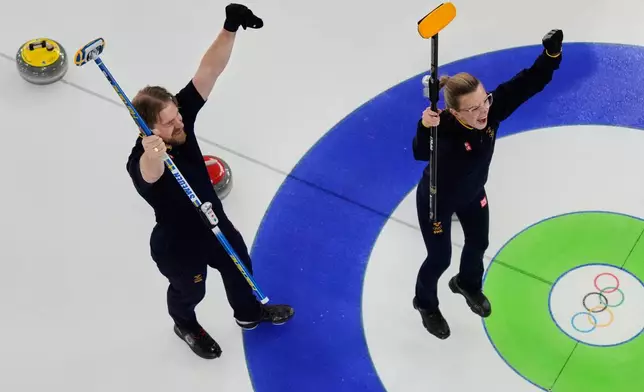 Sweden's Rasmus Wranaa and Isabella Wranaa, right, celebrate after winning the curling mix doubles gold medal match against United States at the 2026 Winter Olympics, in Cortina d'Ampezzo, Italy, Tuesday, Feb. 10, 2026. (AP Photo/Bernat Armangue)