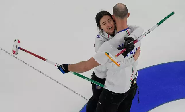 Italy's Amos Mosaner and Stefania Constantini celebrate after winning the bronze medal mixed doubles curling match, at the 2026 Winter Olympics, in Cortina D'Ampezzo, Italy, Tuesday, Feb. 10, 2026. (AP Photo/Bernat Armangue)