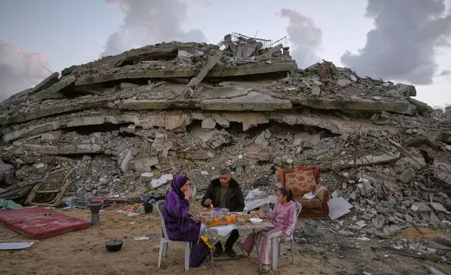 Heba al-Yazji, her husband, Saddam, and their daughter, Maryam, break their fast during the Muslim holy month of Ramadan amid the rubble of destroyed buildings in Gaza City Tuesday, Feb. 24, 2026. (AP Photo/Jehad Alshrafi)
