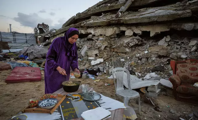 Heba al-Yazji prepares an iftar meal for her husband, Saddam, and their daughter, Maryam, as they break their fast during the Muslim holy month of Ramadan amid the rubble of destroyed buildings in Gaza City Tuesday, Feb. 24, 2026. (AP Photo/Jehad Alshrafi)