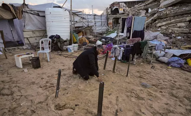 Saddam al-Yazji visits the grave of his brother near the spot where he shelters with his wife and daughter in Gaza City Tuesday, Feb. 24, 2026. (AP Photo/Jehad Alshrafi)