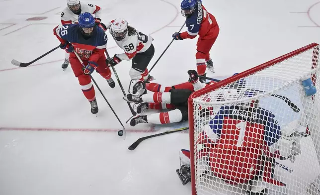 Czechia's forward Vendula Pribylova, left, fights for the puck with Switzerland's forward Leoni Balzer during a preliminary round match of women's ice hockey between Switzerland and Czechia at the 2026 Winter Olympics, in Milan, Italy, Friday, Feb. 6, 2026. (Wikus De Wet/Pool Photo via AP)
