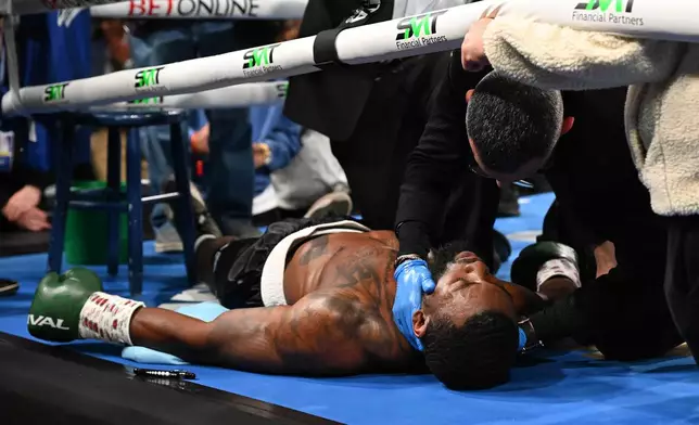 Trainers check on Joe George Jr. after he collapsed in his corner after the first round of his light heavyweight boxing match against Atif Oberlton, Sunday, Feb. 22, 2026, in Detroit. (AP Photo/Lon Horwedel)