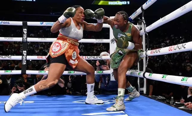 Claressa Shields, right, hits Franchon Cruz-Dezurn with a right in the first round of their Undisputed Heavyweight World Championship boxing match, Sunday, Feb. 22, 2026, in Detroit. (AP Photo/Lon Horwedel)