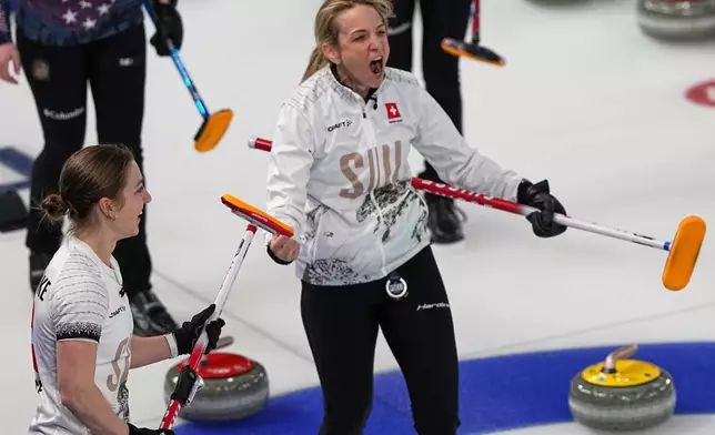 Switzerland's Silvana Tirinzoni, center, and Selina Witschonke celebrate winning a women's curling semifinal match against the United States, at the 2026 Winter Olympics, in Cortina d'Ampezzo, Italy, Friday, Feb. 20, 2026. (AP Photo/Fatima Shbair)